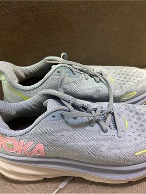 Hoka Womens Pale Blue Running Shoes with Pink Logo and Yellow Accents